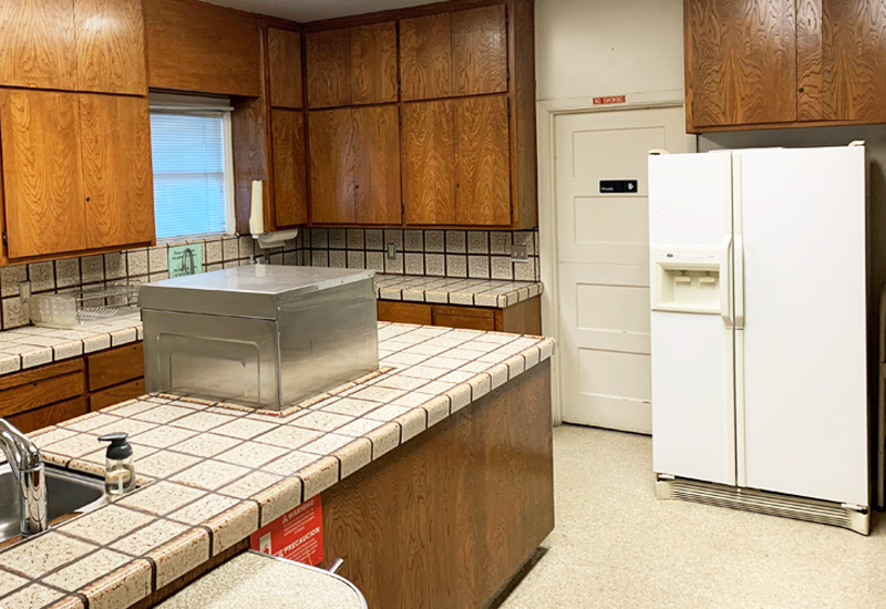 Photo of kitchen showing sink, counters, and fridge