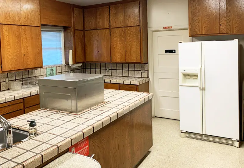 Photo of kitchen showing sink, counters, and fridge