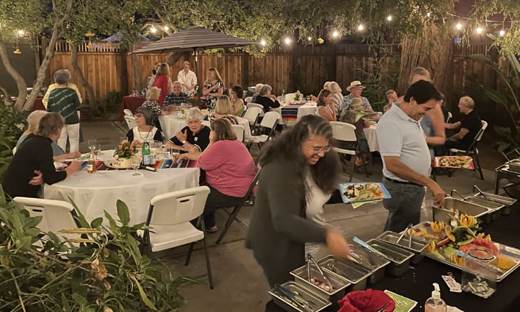 A group of people sitting at tables with food.
