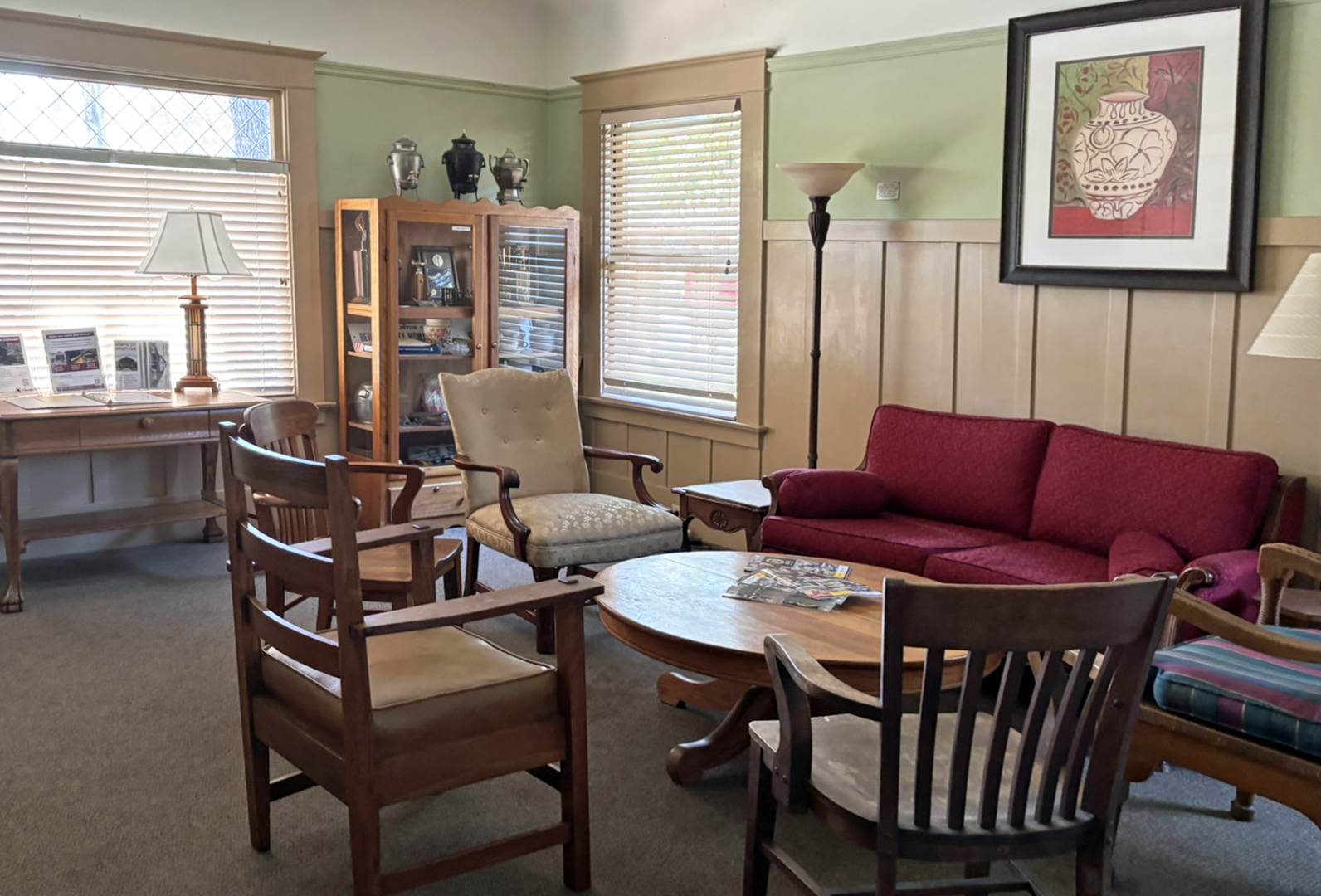Parlor photo Photo of a small parlor room with wooden furniture and a burgundy sofa.