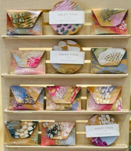 Hand painted wallets in a wooden display case